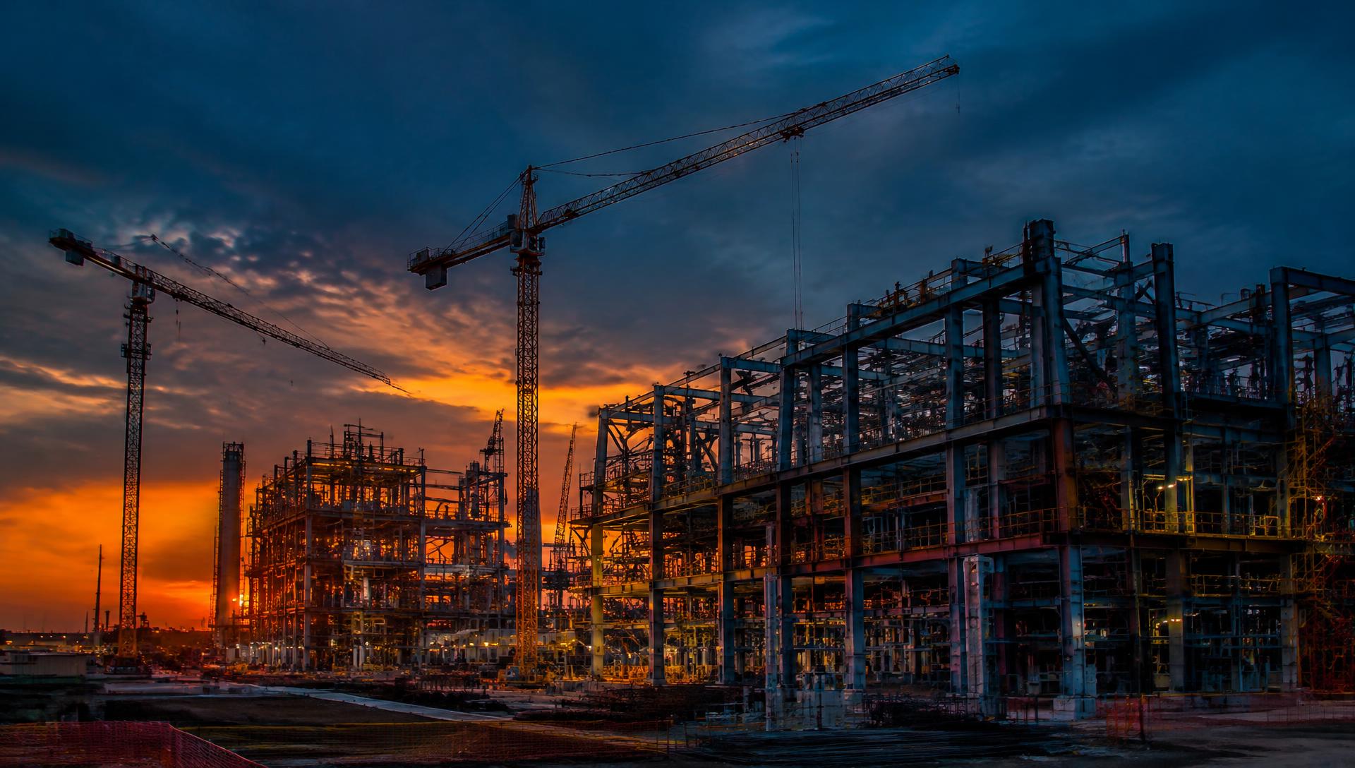 Structural steel industrial plant under construction at dusk